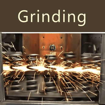 Rectificadora de resortes aplanando los extremos de resortes de compresión de alta resistencia, con chispas visibles durante el proceso.