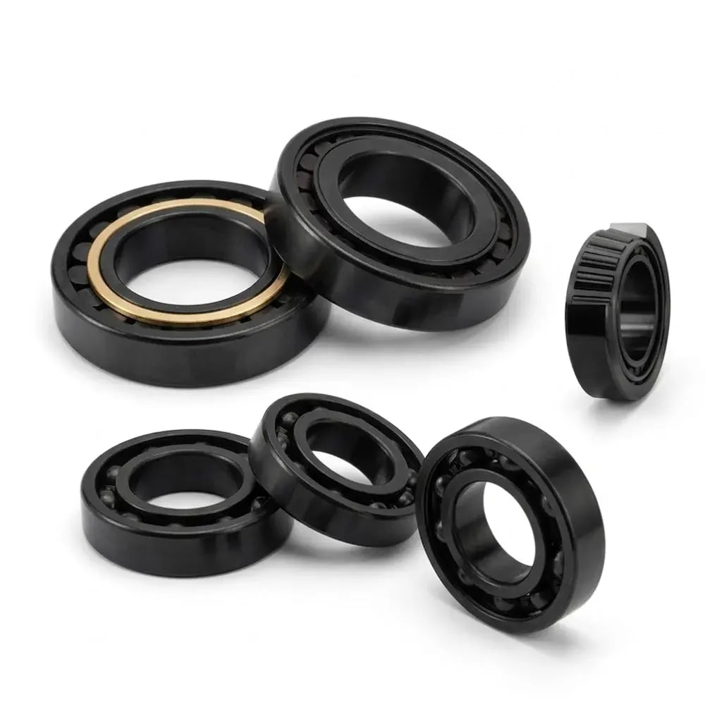 Multiple black oxide coated bearings on white background, including deep groove ball bearings and a tapered roller bearing, showing the characteristic deep black glossy finish of black oxide surface treatment.
